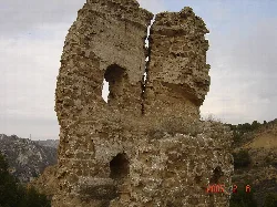 Ruins of the upper part of the castle with stone walls and open windows.