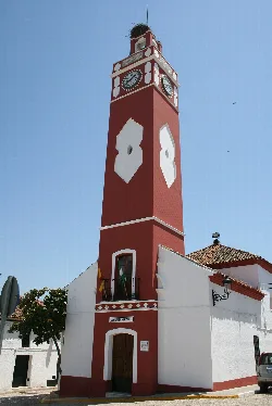 Torre del reloj de color rojo con relojes en la parte superior en Almadén de la Plata.