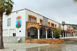 Building in the town hall square with coat of arms and arches in Arroyo de San Serván.