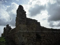 Ruins of an old church with crumbling walls and cloudy sky.
