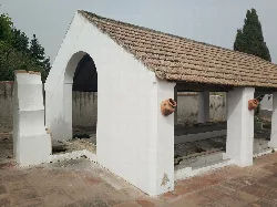 Public washhouse with stone structure and tiled roof in Guadalcázar.