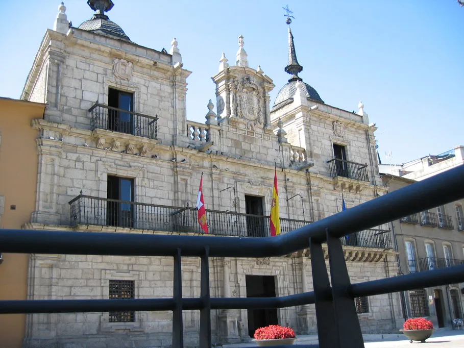 Fachada de un edificio histórico con banderas y detalles ornamentales.