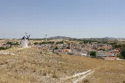 View of a windmill and a town in a rural landscape.