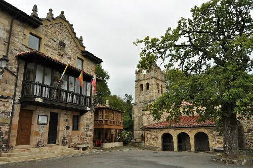 Calles con edificios de piedra y torre en San Pedro del Romeral.