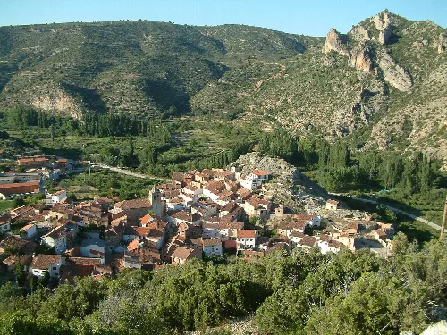 Panoramablick auf El Cuervo in Teruel, mit Bergen und Fluss im Hintergrund.
