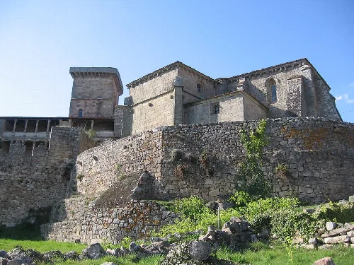 Schloss Monterrei mit Steinmauern und Türmen auf einer grünen Landschaft.