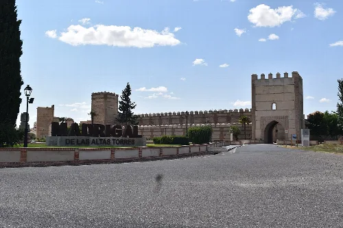 Eingang mit Mauer und Schild in Madrigal de las Altas Torres.