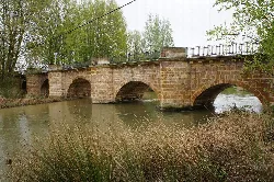 Stone bridge with multiple arches over the river in Herrera de Pisuerga.
