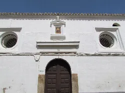 White facade with doors and round windows in Campanario.