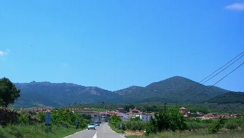 Mountains of Sierra de Algairén behind a village with a road in the foreground.