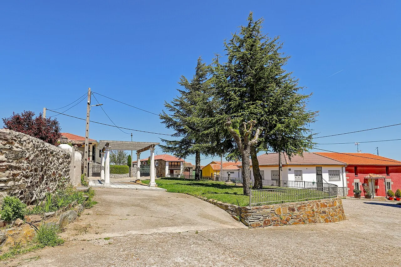 Plaza ajardinada con árboles y casas en Herguijuela del Campo.