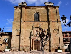 Stone church facade with doors and windows in Huércanos.
