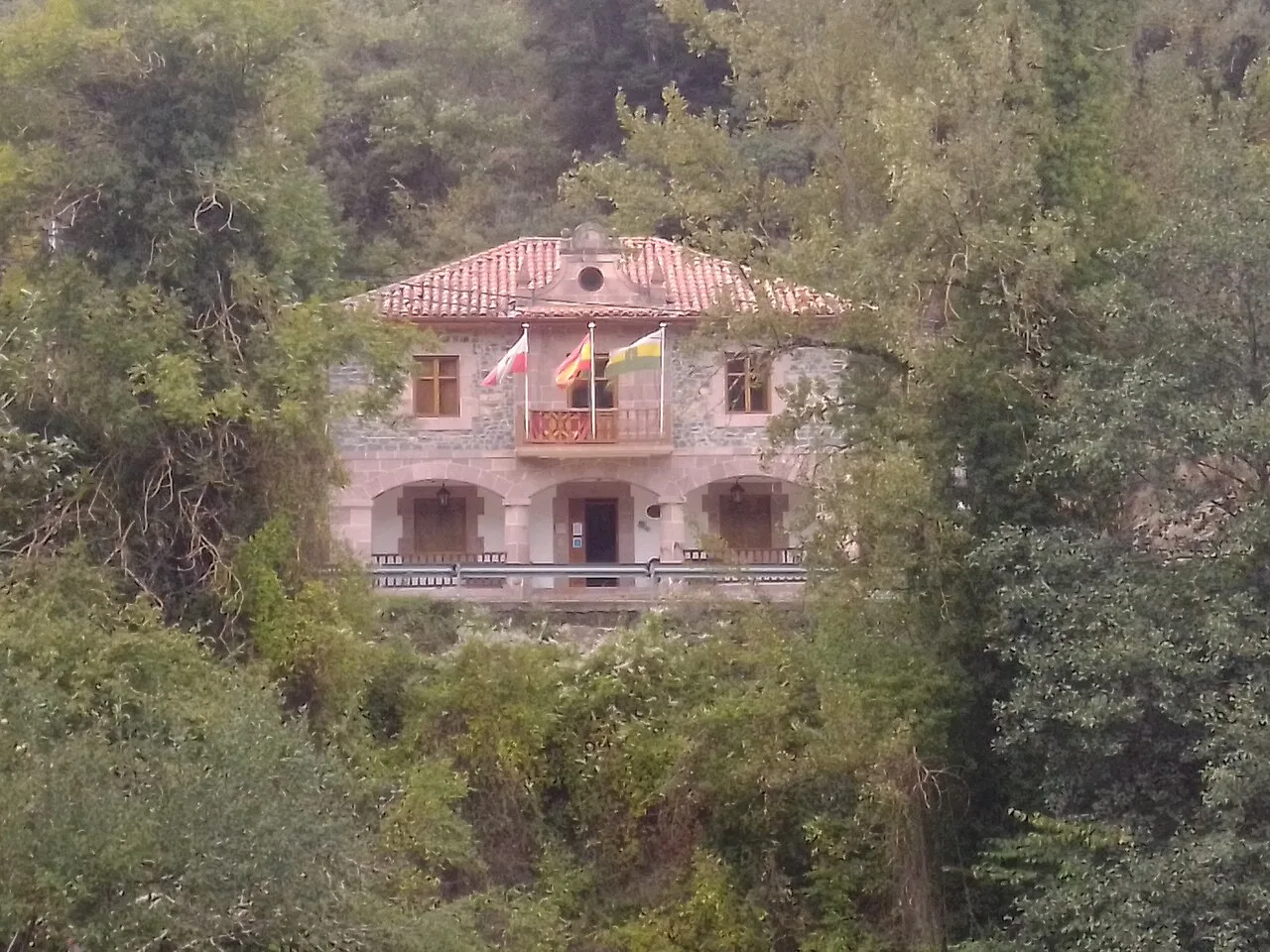 Camaleño town hall among trees.