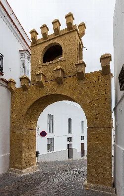 Jerez Gate in Arcos de la Frontera, with arch and stone tower.
