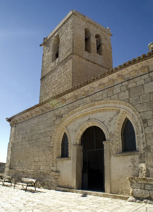 Fachada de iglesia con torre de piedra y arco decorado en Valladolid.