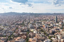 Aerial view of Barcelona city with buildings and mountains in the background
