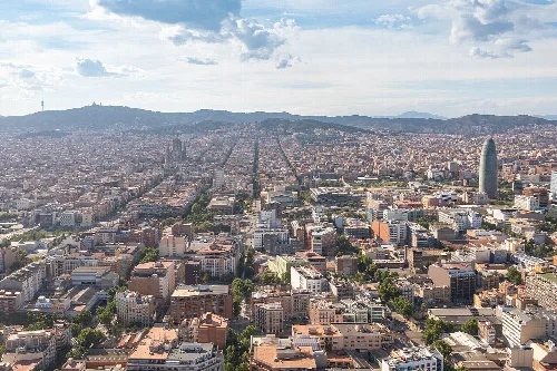 Luftaufnahme der Stadt Barcelona mit Gebäuden und Bergen im Hintergrund
