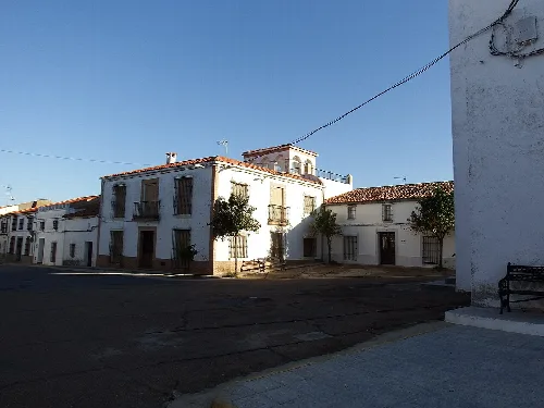 Platz in Sancti-Spíritus mit weißen Gebäuden und Bäumen.