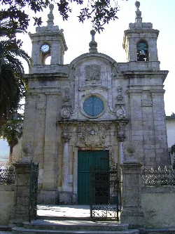 Fachada de piedra con campanarios y reloj en Mondoñedo.