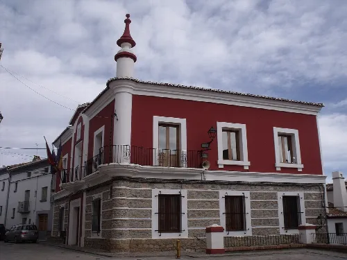 Town hall building with a red facade and corner tower in Teresa.