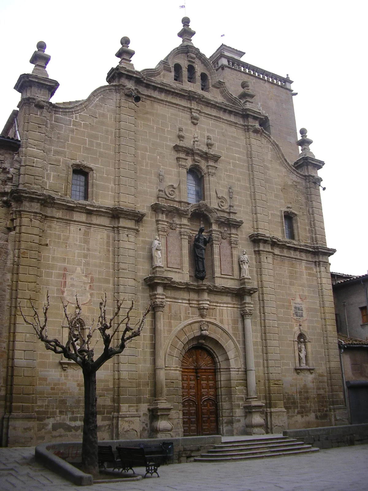 Steinfassade der Santa Maria Kirche in Guissona mit religiösen Skulpturen.