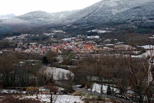 Blick auf Valgañón mit Schnee und Bergen im Hintergrund.