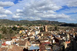 Panoramic view of Calles with houses and mountains in the background.
