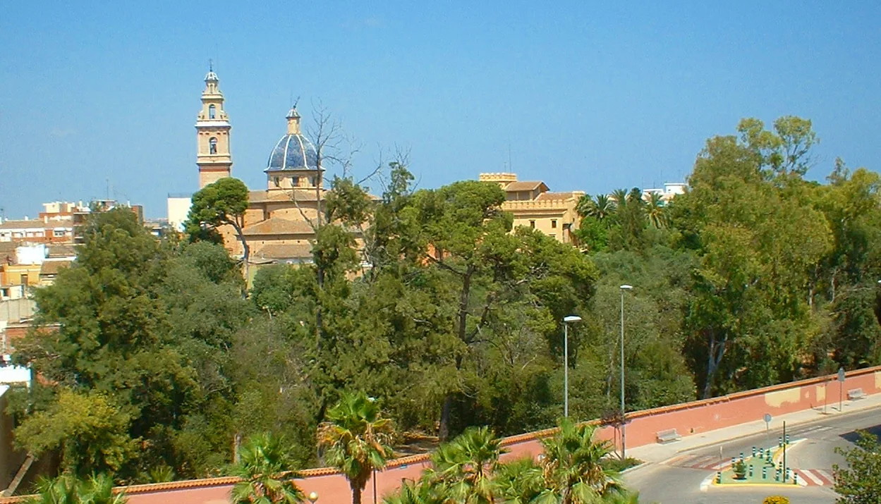 Árboles y edificios con la iglesia de Sant Miquel y la Devesa del Castell en Burjasot.