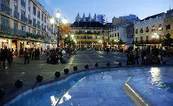 Ciudad Real's Plaza Mayor with people and lit buildings at sunset.