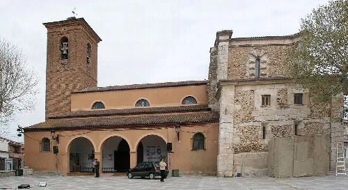 Facade of a church with a brick bell tower in Marchamalo.