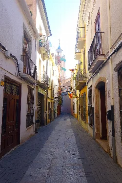 Narrow street with buildings and balconies in Arenys de Mar