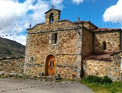 Stone sanctuary façade with wooden door in Laviana.