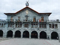 Building in Leitza with arches on the ground floor and a clock on top.