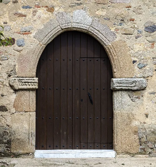 Puerta lateral de la Iglesia Parroquial de Trujillanos, municipio de Badajoz, España. Se observan dos piezas de piedra labrada de origen visigodo en cada una de sus jambas laterales.