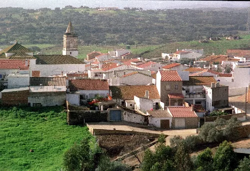 Vista de casas blancas y una iglesia con torre en El Granado.