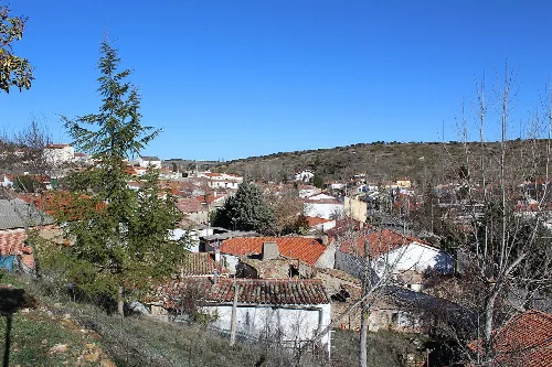Landschaft mit Häusern, Bäumen und Hügeln in Beleña.