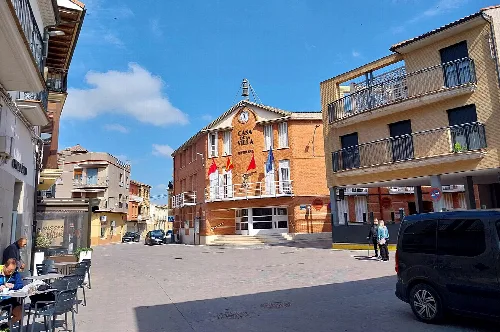Platz mit Gebäuden und Menschen in Fustiñana, Navarra, an einem sonnigen Tag.