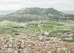 Vista aérea de un pueblo con una montaña en el fondo.