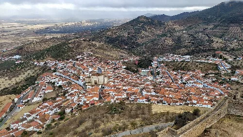 Luftaufnahme von Feria, Badajoz, vom Schloss, mit roten Dächern und Straßen.