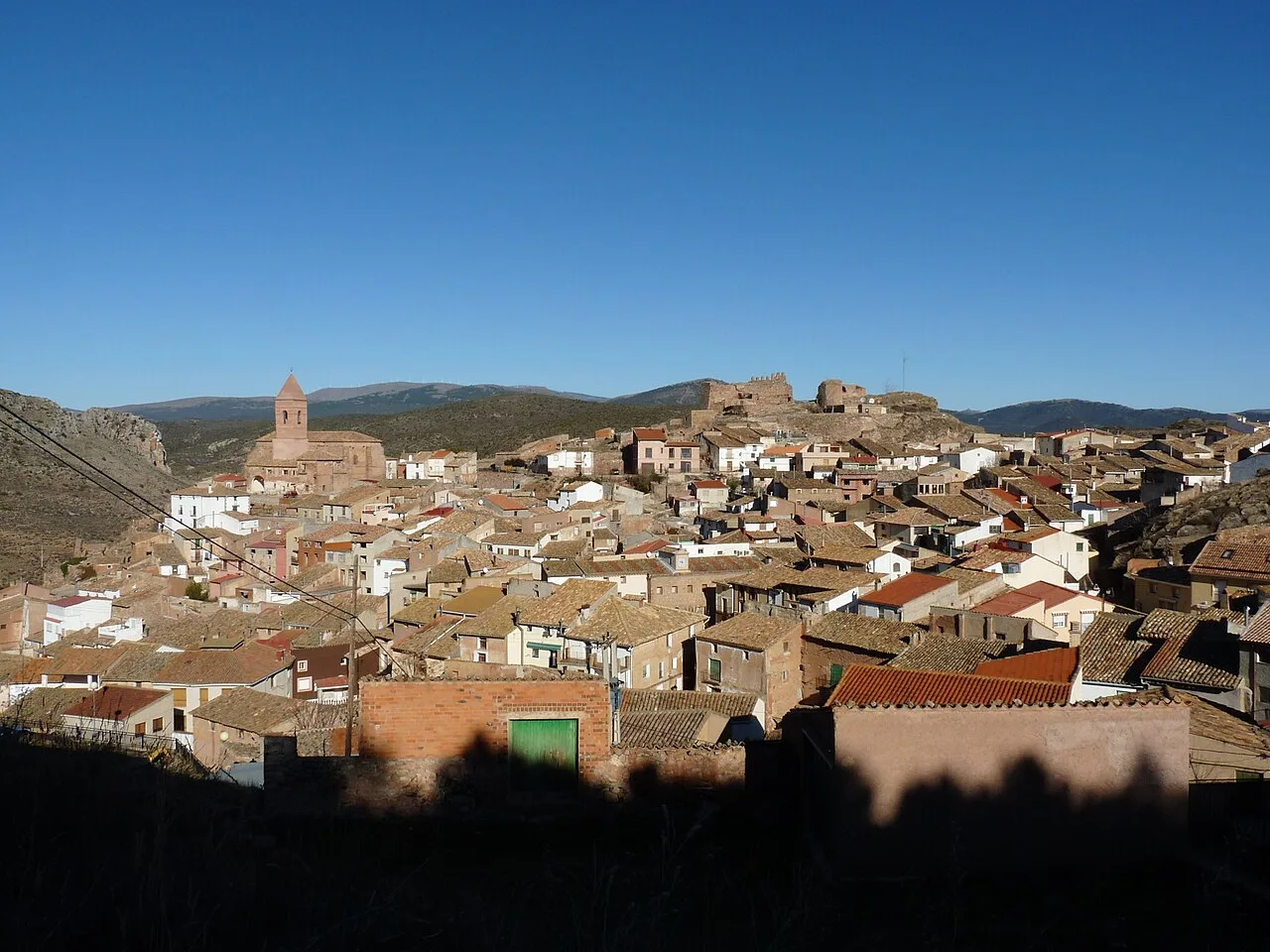 Paisaje urbano de Aranda de Moncayo con casas y castillo en las colinas.