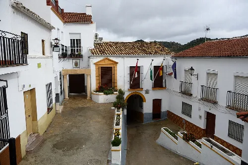 Rathaus in Torre Alháquime mit Flaggen und weißen Häusern.