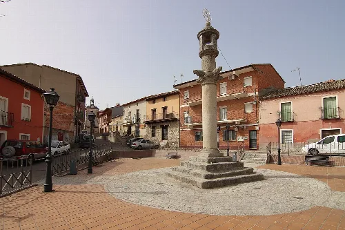 Fuente en la plaza de la Constitución en Nombela con edificios y calles cercanas.