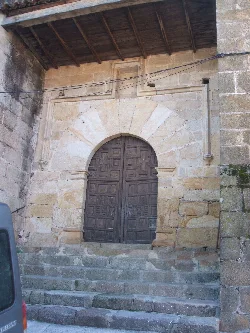 Holztür mit Steinbogen an der Kirche von Villanueva de la Sierra.
