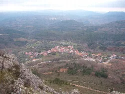 Vista del pueblo de Garcibuey desde una montaña con casas y caminos rurales.