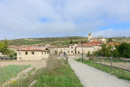 Path and houses in Susinos del Páramo with church in the background