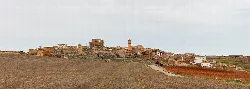 Panoramablick auf ein ländliches Dorf mit Steinhäusern in einer Landschaft.