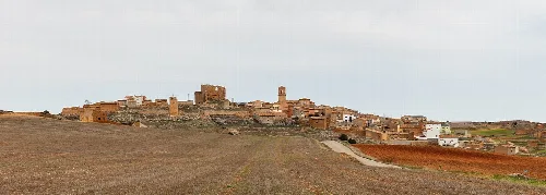 Panoramic view of a rural village with stone houses in a countryside landscape.