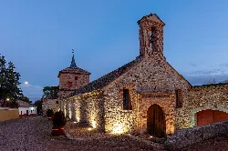 Iglesia antigua de piedra con campanario y puerta de madera en Santa Cruz de Mudela.