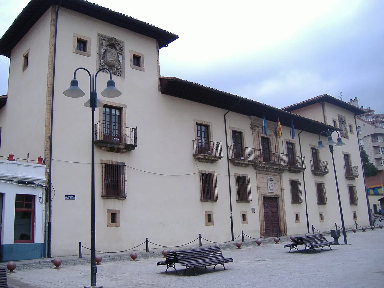 Rathaus mit Flaggen und Bänken auf dem Platz in Cangas del Narcea.