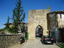 Puerta de la muralla en Bernedo con arco de piedra y edificios antiguos
